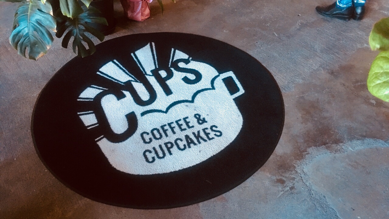「CUPS　コーヒー＆カップケーキ」のエントランスマット